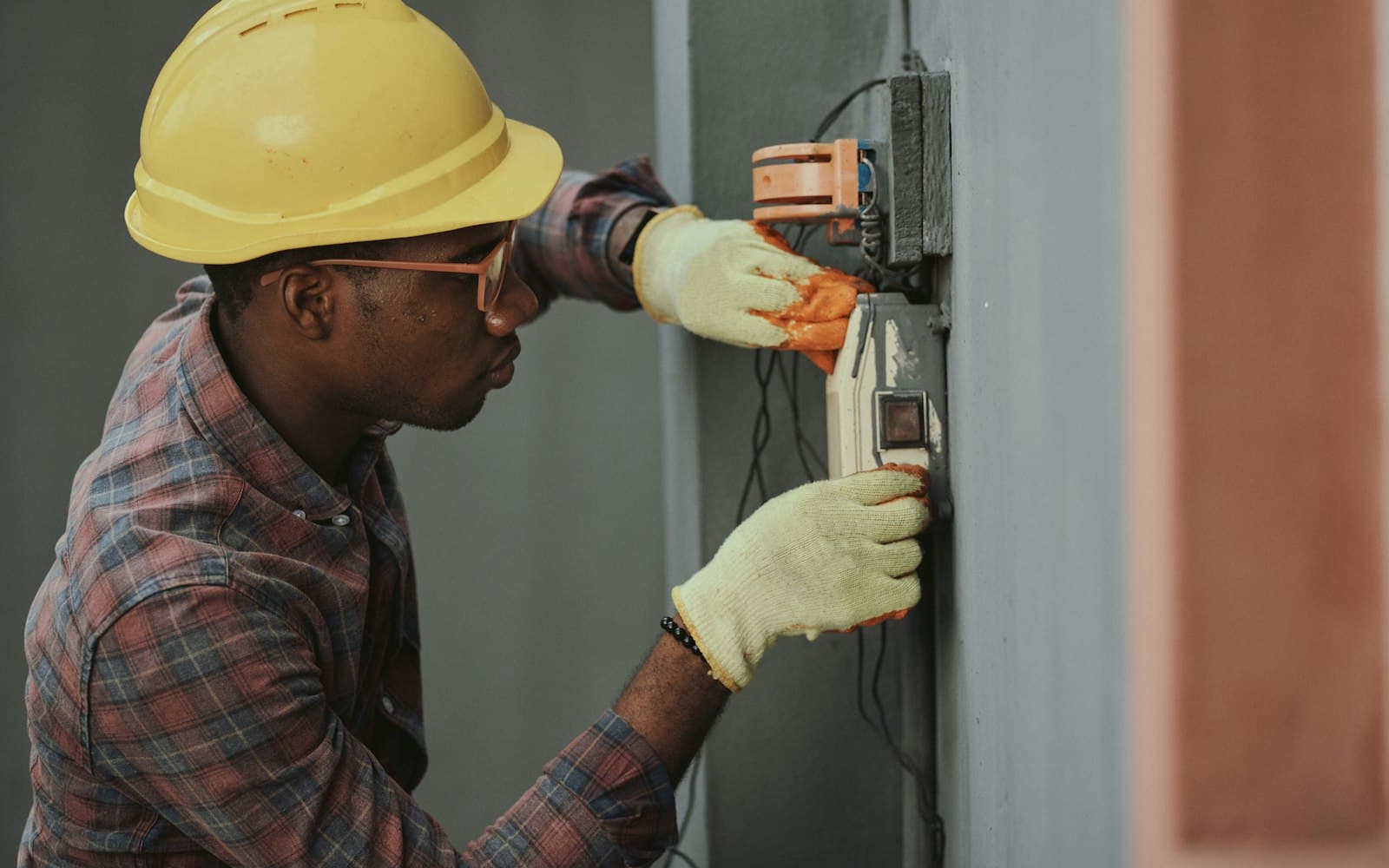 Electrician installing wiring wearing a hard hat